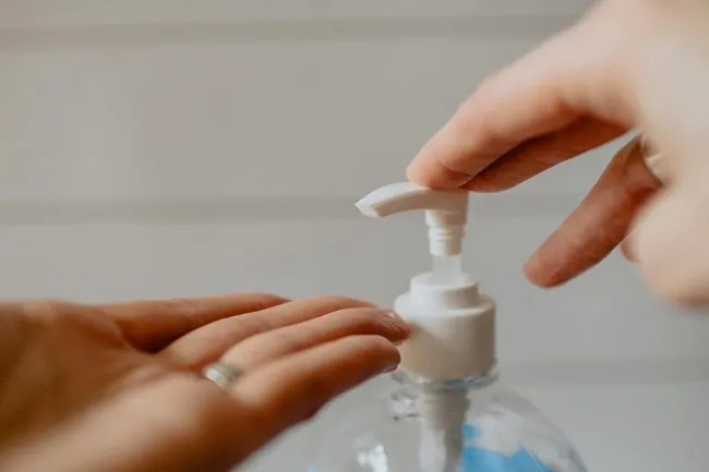 A person washes his hands with a liquid sanitizer.