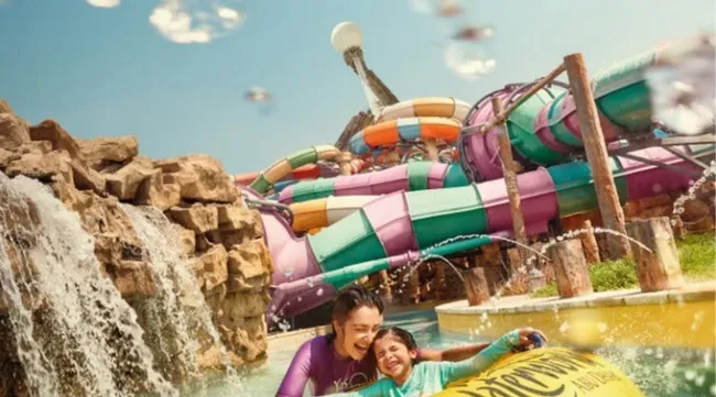 Happy family on water slide at Yas Waterworld in Abu Dhabi.